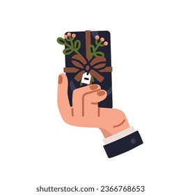 Hand holding gift box, corporate present. Holiday surprise wrapped in festive black wrapping, tied with ribbon bow, decorated with flower branch. Flat vector illustration isolated on white background