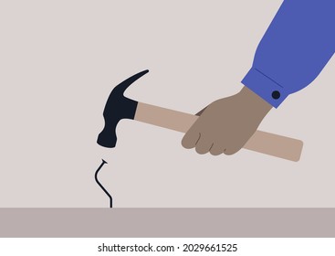 A hand holding a hammer and hitting a metal nail, a failure, manual work problems