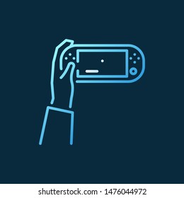 Hand holding Handheld Game Console vector concept colored icon in outline style on dark background