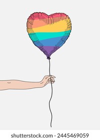 Hand holding a heart shape rainbow balloon