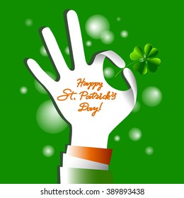 Hand holding irish four leaf lucky clovers background for Happy St. Patrick's Day.
