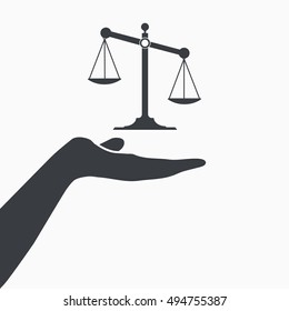 Hand holding justice scale