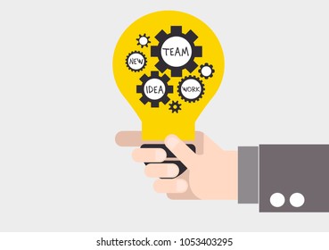 hand holding a light bulb with gears inside