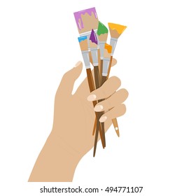 Hand holding paint brushes. set of brushes in different styles