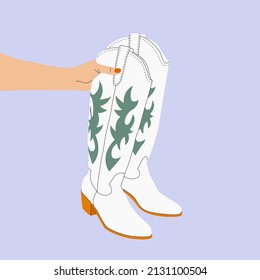 Mano sosteniendo un par de botas blancas de vaquera. Chica de vaca lleva botas. Moda occidental de vaquero, occidente silvestre, texas, moda. Varias botas de vaquera. Dibujo a mano a color trendy vectorial ilustración aislada. 