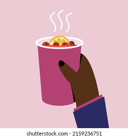 Hand holding a paper cup with hot tea with lemon and berries. 