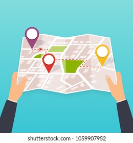 Hand holding a paper map. Tourist look at map of the city. Vector Illustration in flat design. Travel concept.