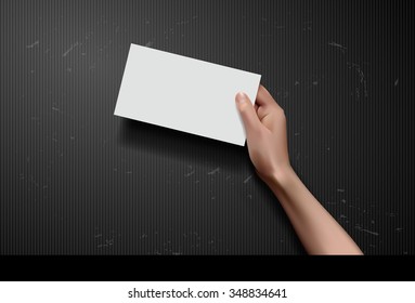 Hand holding paper on black background
