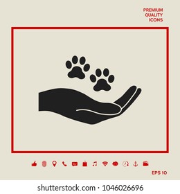 Hand holding paw symbol. Animal protection