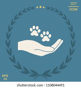 Hand holding paw symbol. Animal protection