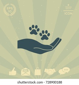 Hand holding paw symbol. Animal protection