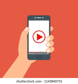 Hand holding phone icon. Vector illustration. There is a "play" button on the display of the smartphone in the picture