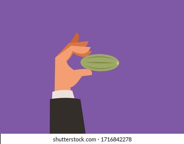 Hand holding pickle pinched between fingers.