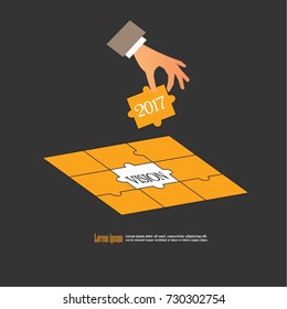  Hand holding piece of jigsaw puzzle with word 2017 VISION .