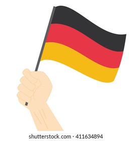 Hand holding and raising the national flag of Germany