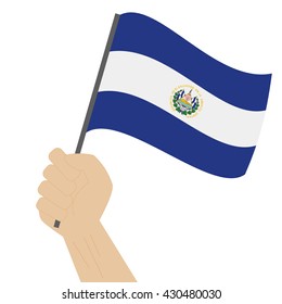 Hand holding and raising the national flag of El Salvador