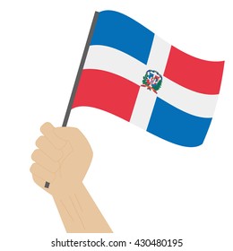 Mano sosteniendo y alzando la bandera nacional de República Dominicana