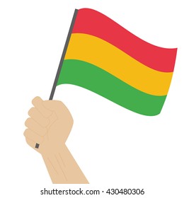 Hand holding and raising the national flag of Bolivia