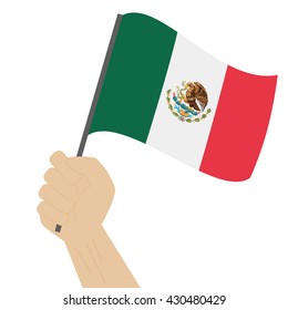 Hand holding and raising the national flag of Mexico