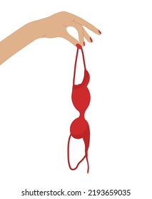 Hand holding red bra in consept of breast awareness. Brassiere hanging isolated.