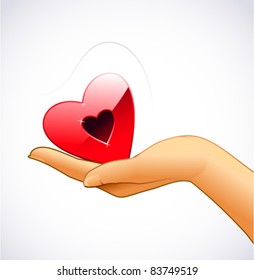 Woman’s hand is holding red heart