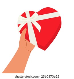 Hand holding red heart shaped gift box with white ribbon and bow