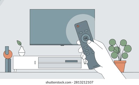 Hand holding a remote control and pointing it towards a modern wall mounted television in a cozy living room.
