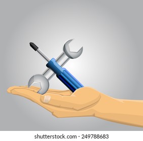 Hand holding a screwdriver and a wrench
