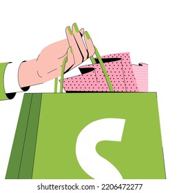 The hand is holding a shopify package.