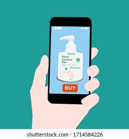 Hand holding smart phone with buy button on the screen. Contactless online purchase of goods using your phone. Use Hand sanitizer pump bottle. Diseases prevention (coronavirus). Home delivery.