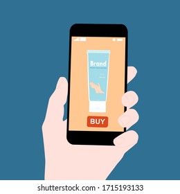 Hand holding smart phone with buy button on the screen. Contactless online purchase of goods using your phone. Use Hand sanitizer tube. Diseases prevention (coronavirus). Home delivery.