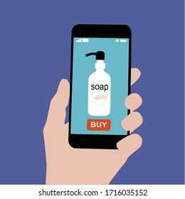 Hand holding smart phone with buy button on the screen. Contactless online purchase of goods using your phone. Use Hand Soap. Liquid pump bottle. Diseases prevention (coronavirus). Home delivery.