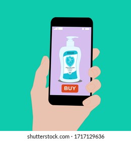 Hand holding smart phone with buy button on the screen. Contactless online purchase of goods using your phone. Use Hand Soap. Liquid pump bottle. Diseases prevention (coronavirus). Home delivery.
