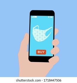 Hand holding smart phone with buy button on the screen. Contactless online purchase of goods using your phone. Use fabric mask. Home delivery. Disease prevention concept.