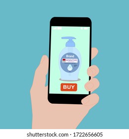 Hand holding smart phone with buy button on the screen. Contactless online purchase of goods using your phone. Use Hand wash soap pump bottle. Diseases prevention. Home deliVery.