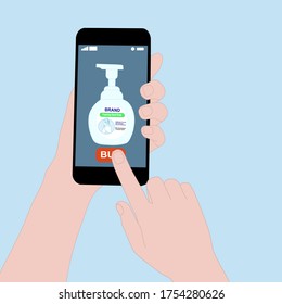 Hand holding smart phone with buy button on the screen. Contactless online purchase of goods using your phone. Use Hand Soap. Foaming pump bottle. Wireless technology. Home delivery