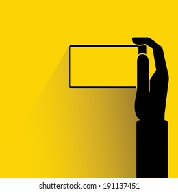 hand holding smart phone on yellow background 