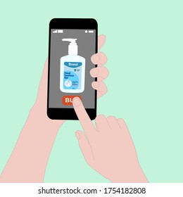 Hand holding smart phone and press buy button on the screen. Contactless online purchase of goods using your phone. Use Hand sanitizer pump bottle. Wireless Technology. Home delivery.