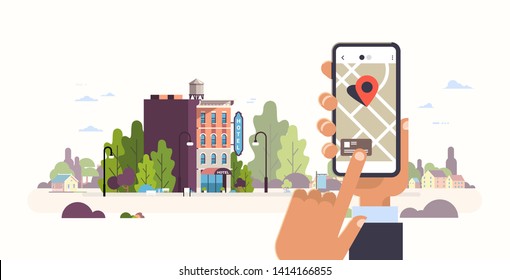 Hand holding smartphone booking hotel concept. Hostel building exterior.  Mobile app searching gps point on city map and cityscape background. flat horizontal banner