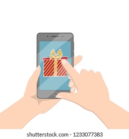 A hand is holding a smartphone. Box with a gift on the smartphone screen. Choosing a gift on the Internet, a gift to a friend.