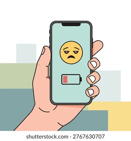 Hand holding a smartphone displaying a low battery icon and a sad emoji, indicating device is running out of power.