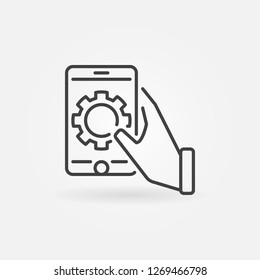 Hand holding smartphone with gear vector outline icon or symbol