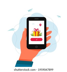 Hand holding smartphone with gift box on a screen. gift and win concept, receiving a gift