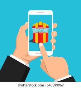Hand holding smartphone with gift box on the screen. Finger touch the button. Vector flat illustration.