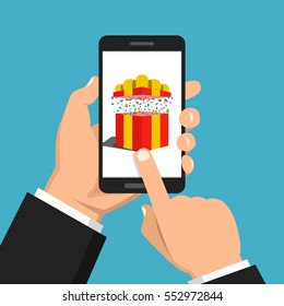 Hand holding smartphone with gift box on the screen. Finger touch the button. Vector flat illustration.
