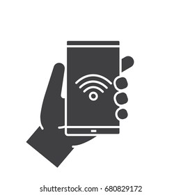 Hand holding smartphone glyph icon. Silhouette symbol. Smart phone wifi connection. Negative space. Vector isolated illustration