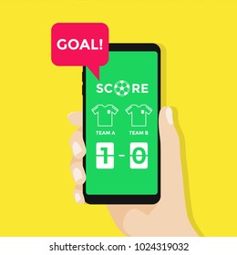 Hand holding smartphone with live score soccer or football application on screen.