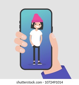 Hand holding a smartphone. Millennial female character standing on a mobile phone screen. Flat editable vector illustration, clip art