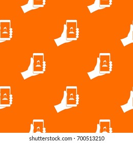 Hand holding smartphone with photo pattern repeat seamless in orange color for any design. Vector geometric illustration