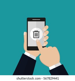 Hand holding smartphone with trash bin icon. Delete concept